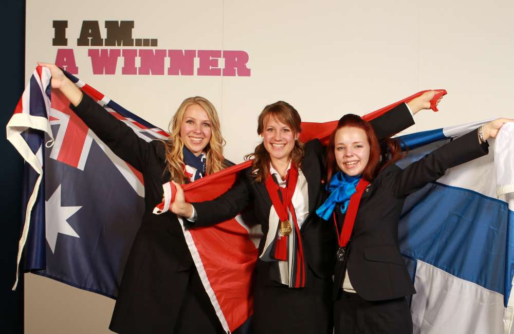 Three competitors celebrate at a WorldSkills competition
